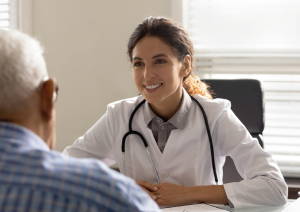 Kvinnelig lege som snakker med eldre mann