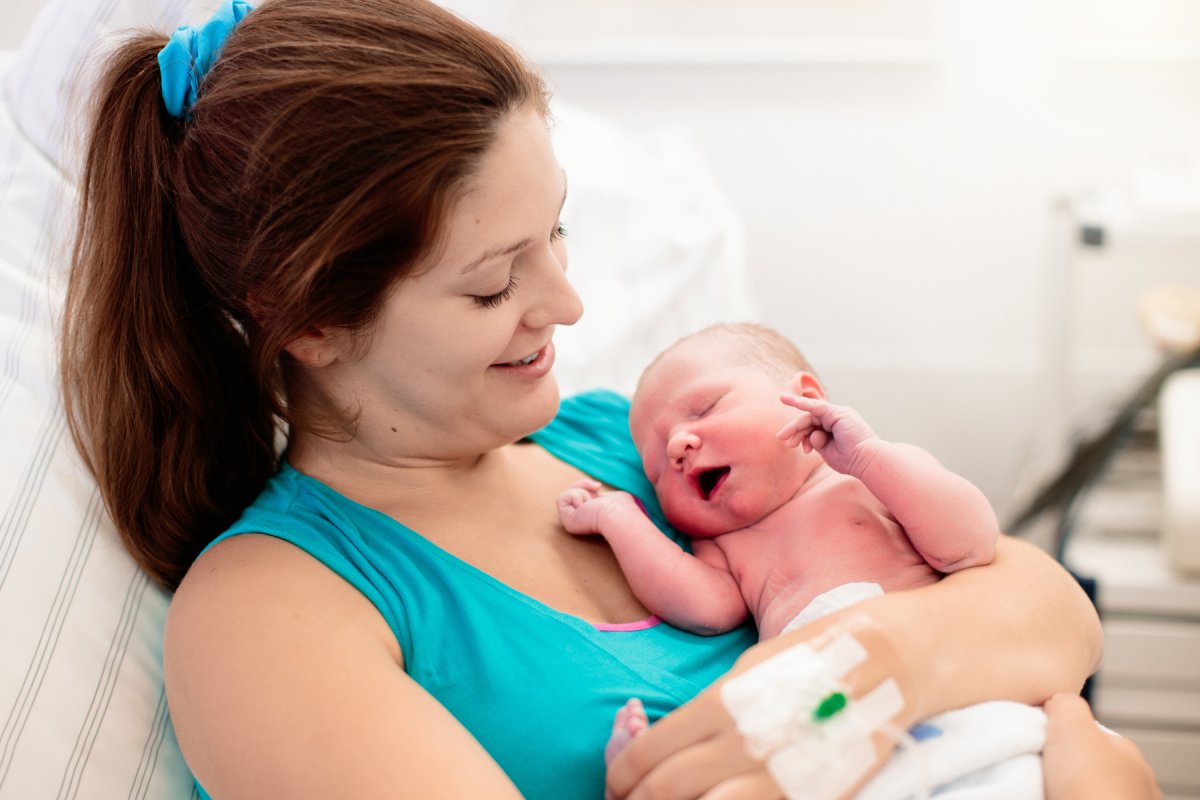 Kvinne med nyfødt baby i armene