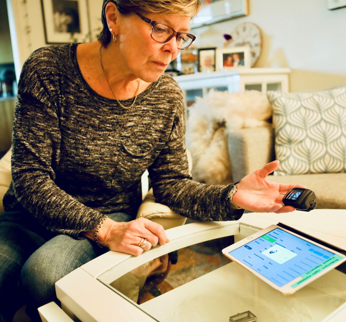 Kvinner bruker velferdsteknologi hjemme ved stuebordet.