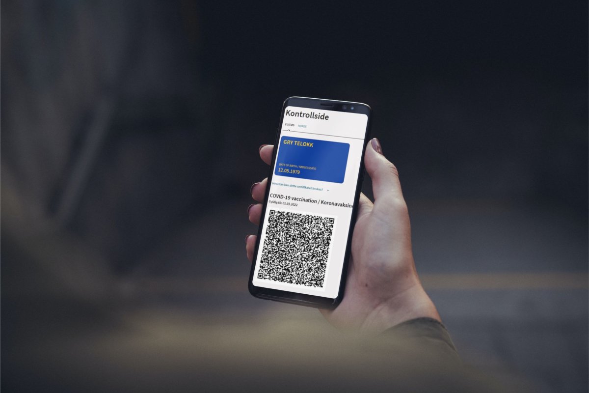 Illustrasjonsbilde av hånd med mobil som viser koronasertifikat