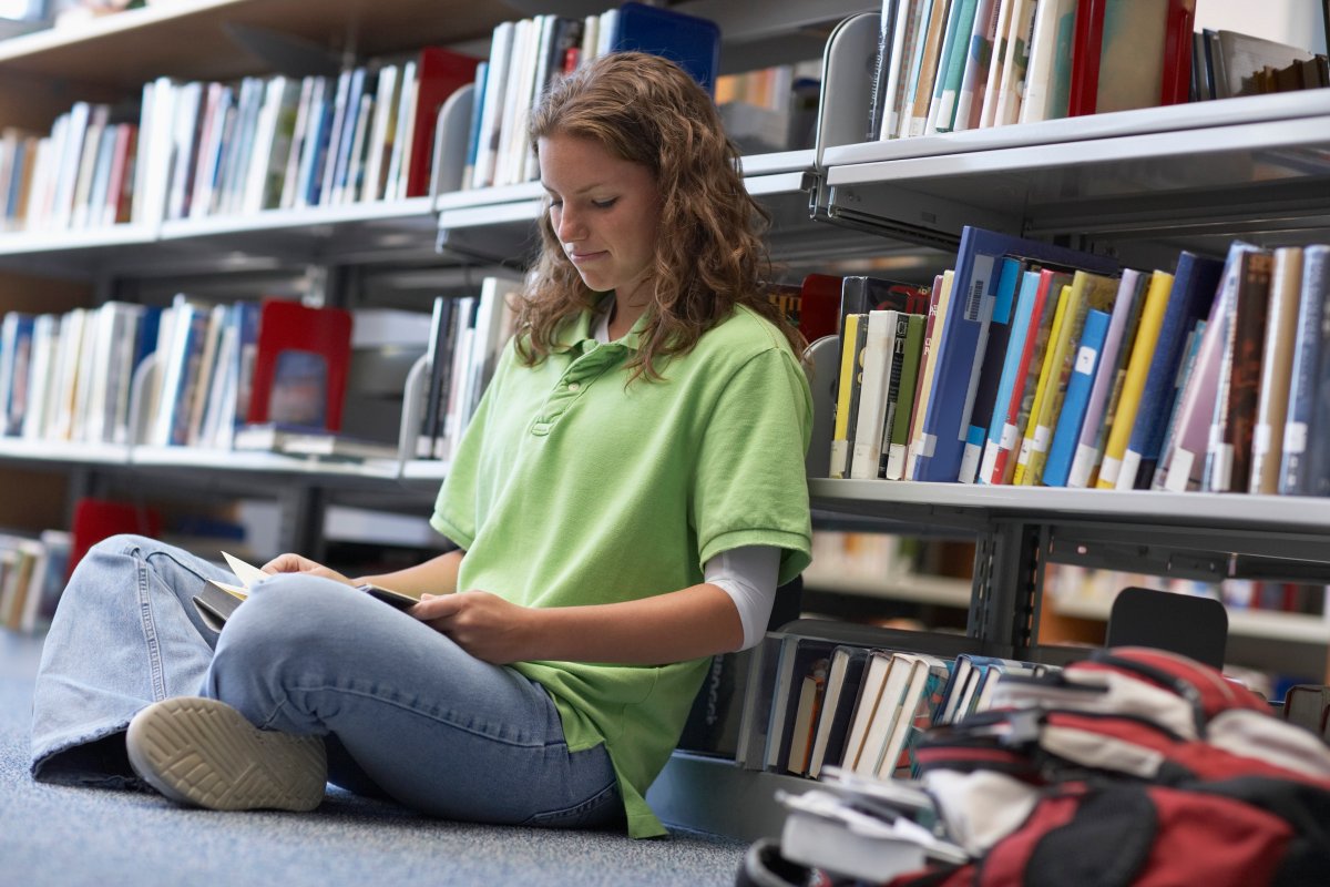 Ung unge på bibliotek.