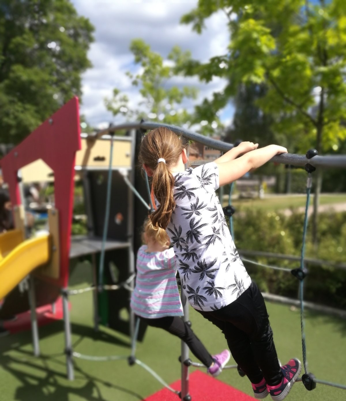 To små barn i klatrestativ på lekeplass