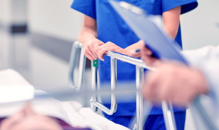 Bilde av legepersonell ved en sykeseng.