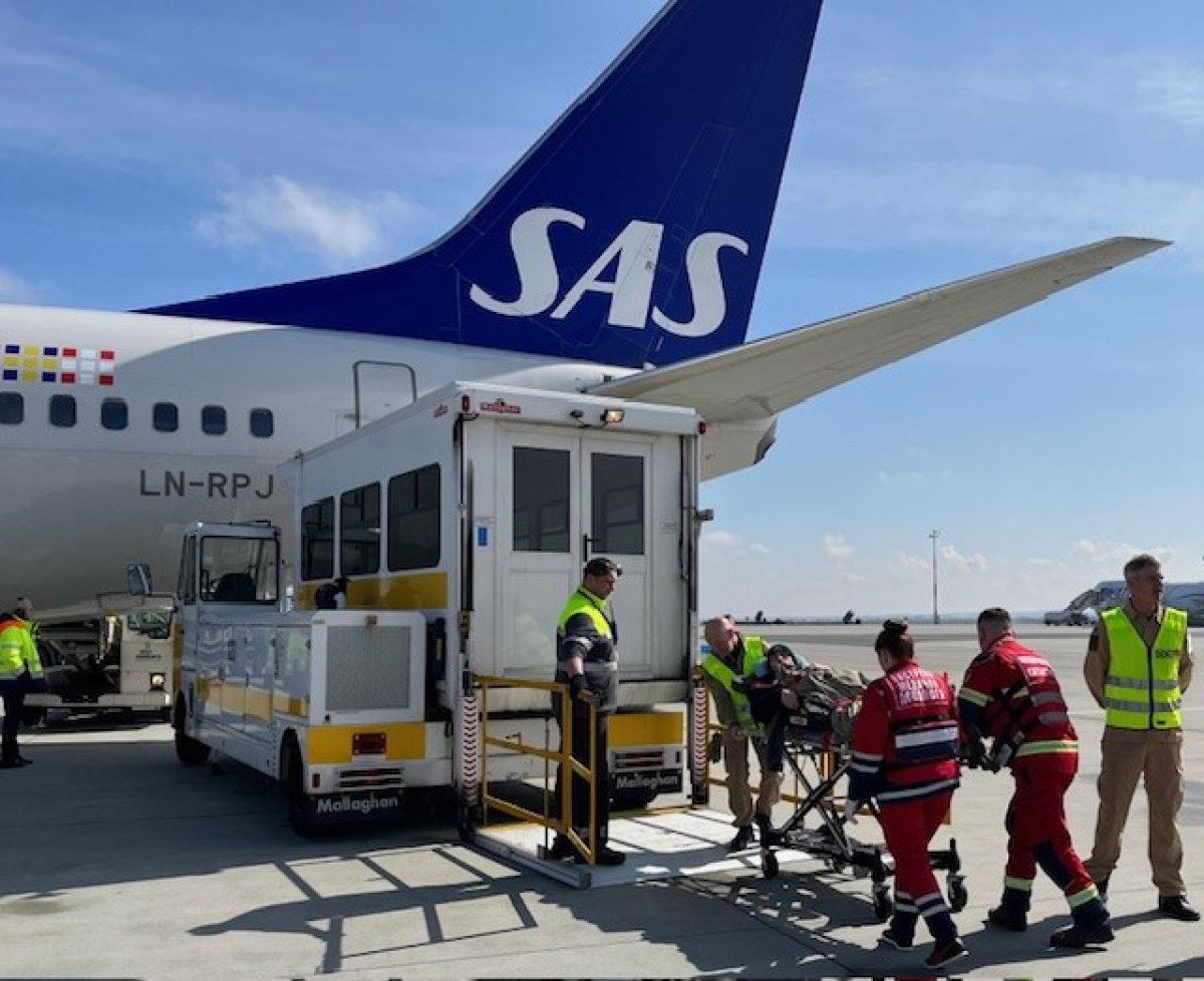 Medisinsk evakuering. Personell frakter skadet person inn i fly