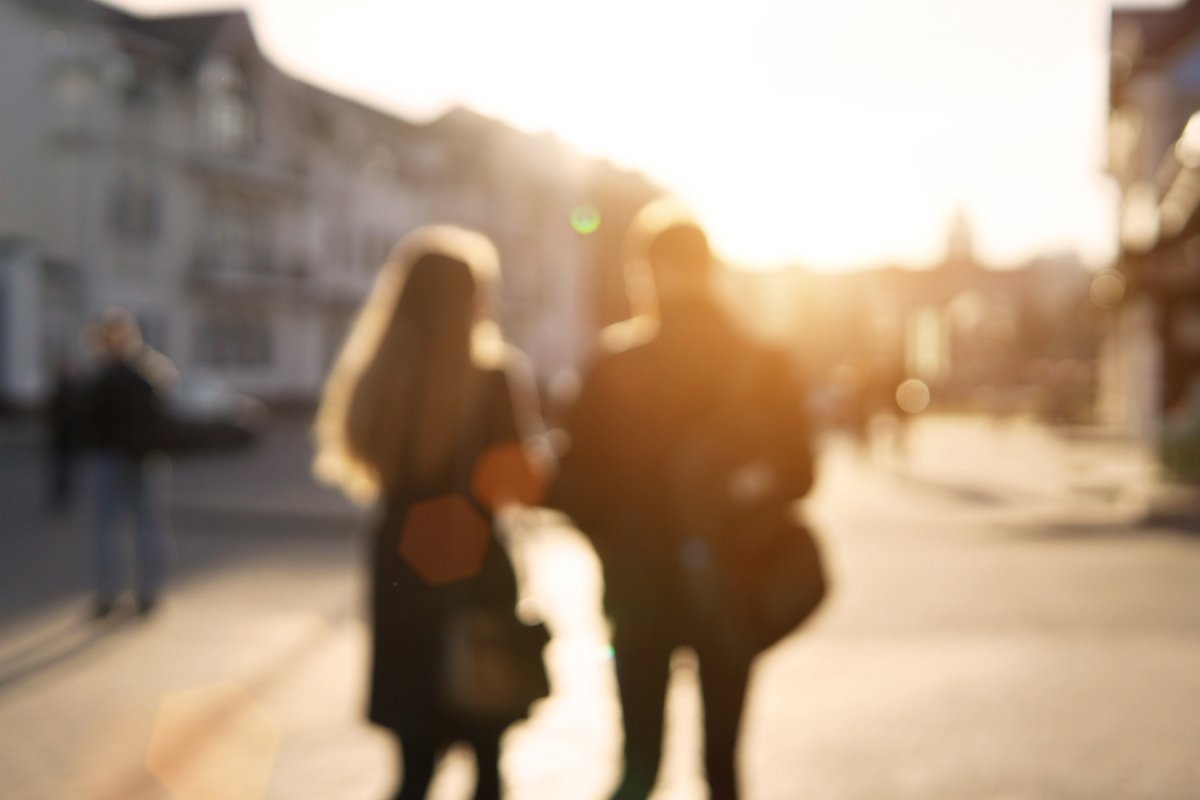 to mennesker med ryggen til går i en gate