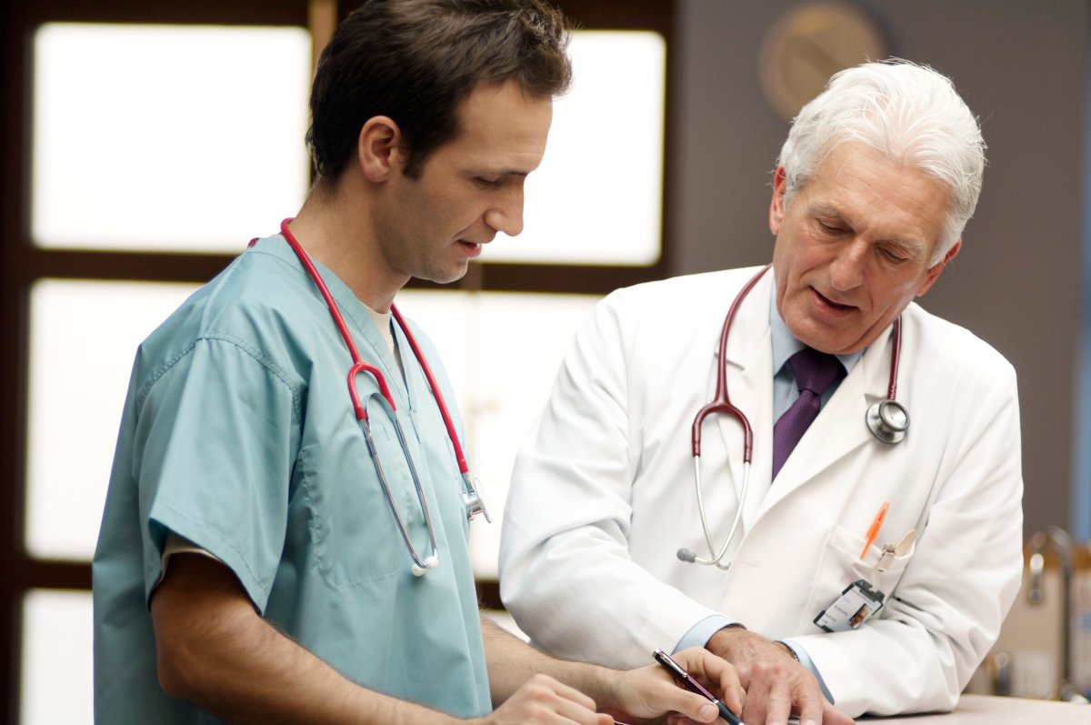 Leger som snakker sammen over et ark