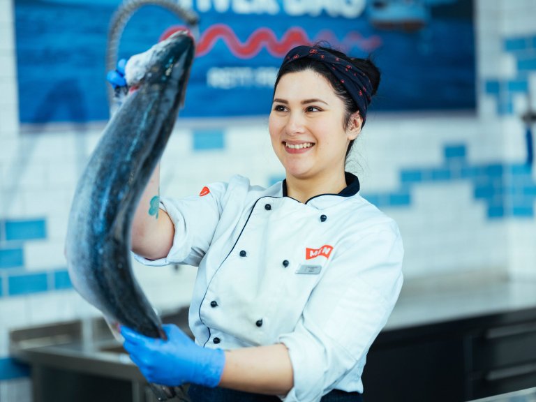 Bilde av dame som holder fisk. Foto MENY.